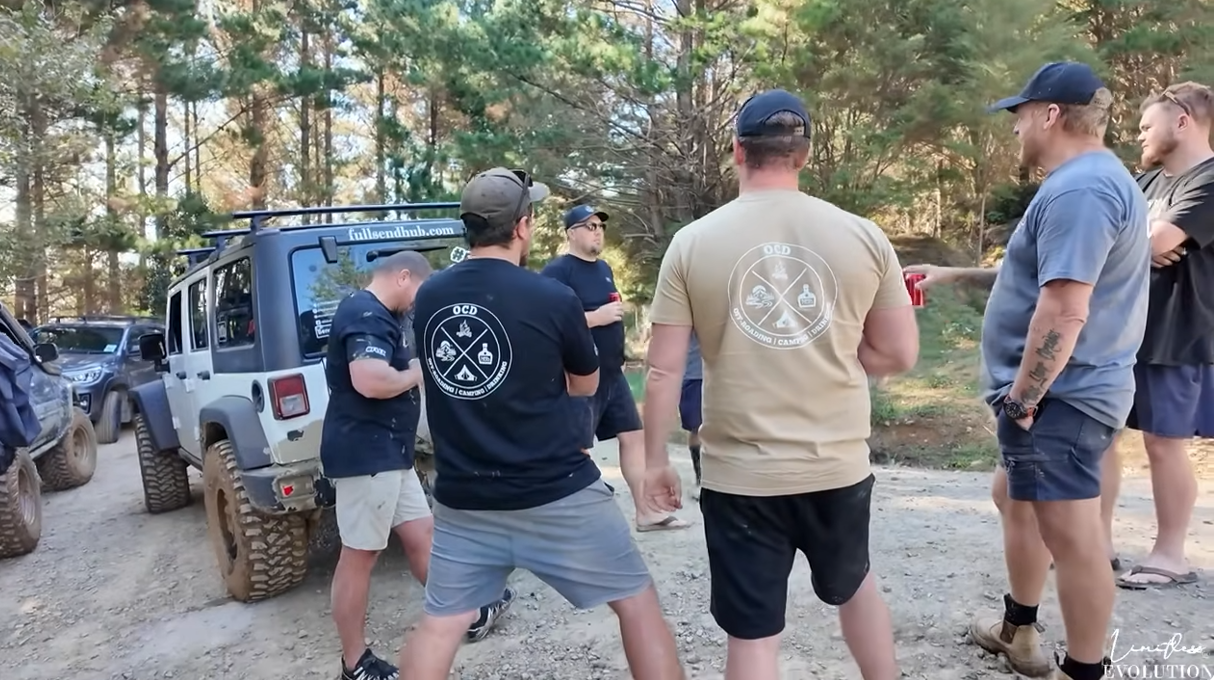 Full Send Hub OCD tees featuring off-roading, camping, and drinking themes worn by Kiwi 4x4 enthusiasts at a New Zealand bush trail